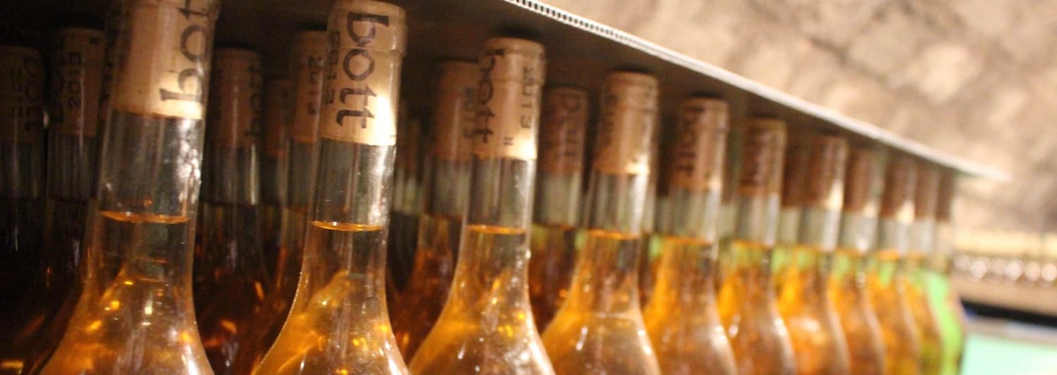Bottles of Tokaji wine resting in a cellar